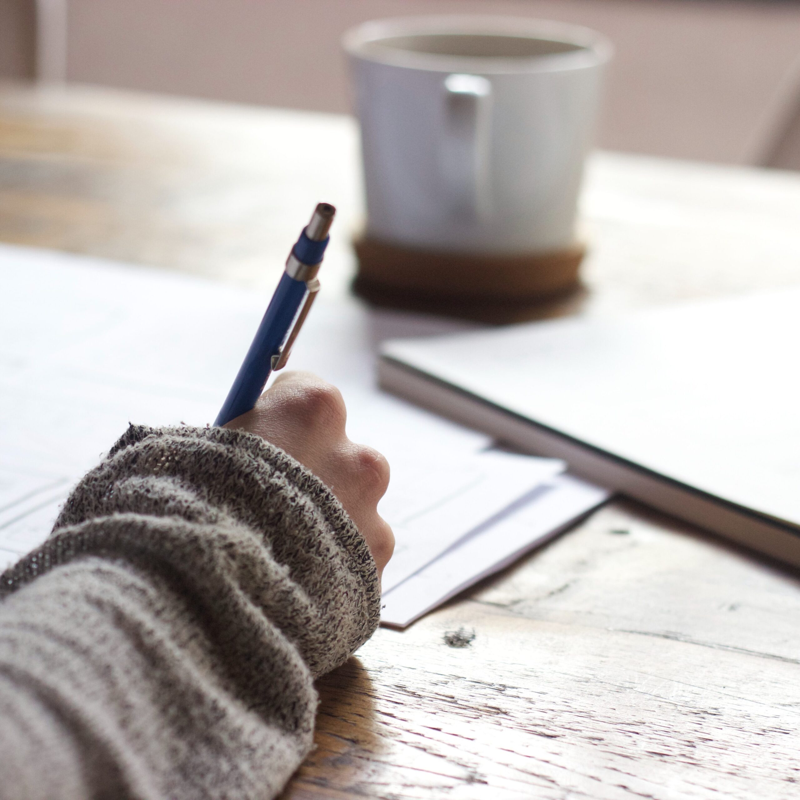 Picture of someone writing. that is meant to represent annotations while dissecting a research journal. 