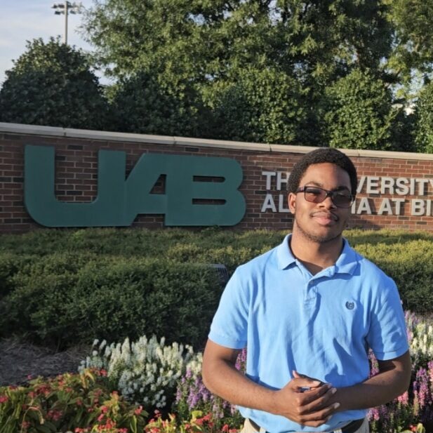 Stanley Stoutamire standing in front of a university sign.