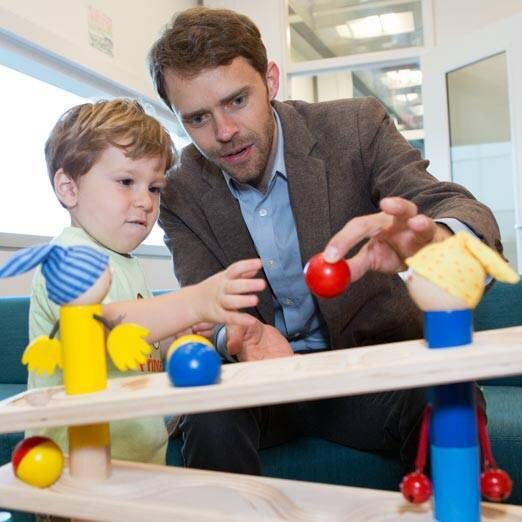 Professor Casey Lew-Williams playing with a toddler visiting the Baby lab.
